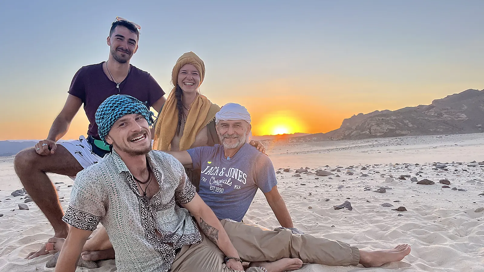 Gruppe lacht beim Sonnenuntergang in der Sinai-Wüste
