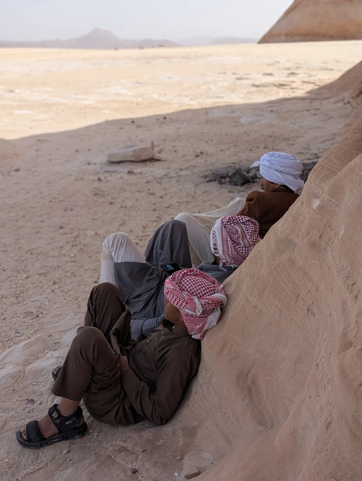 Beduinen ruhen sich im Schatten eines Felsens in der Wüste Sinai aus