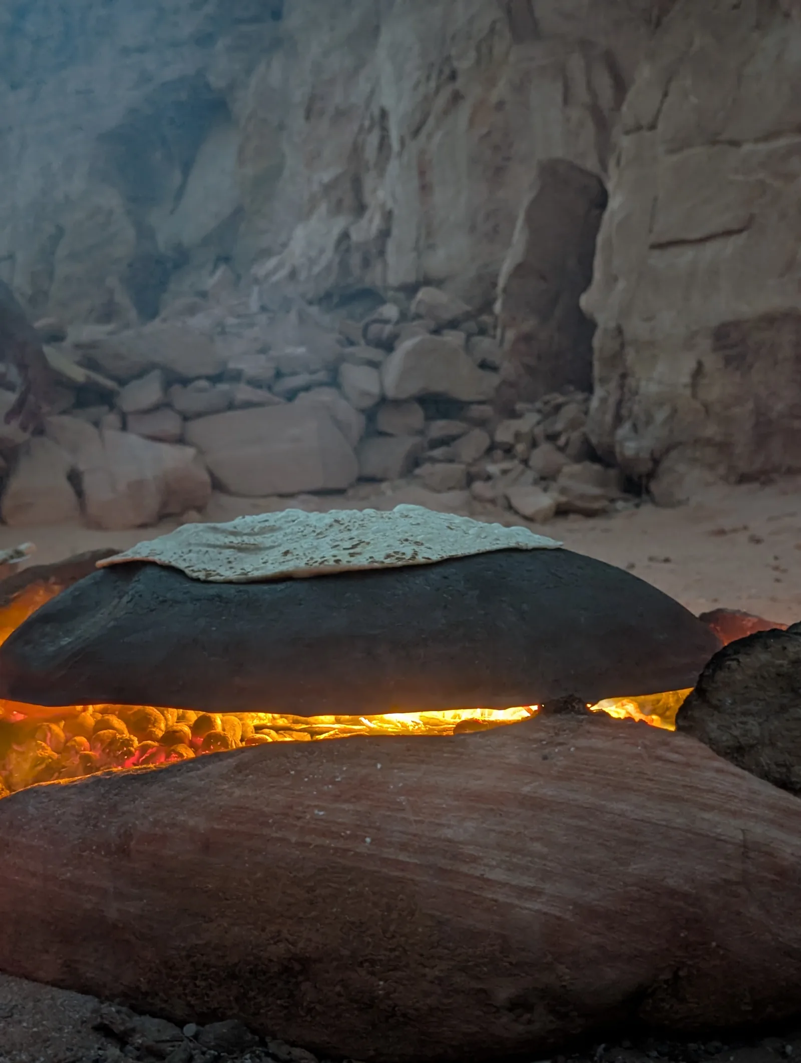 Beduinisches Brot backt auf der Glut des Lagerfeuers in der Wüste