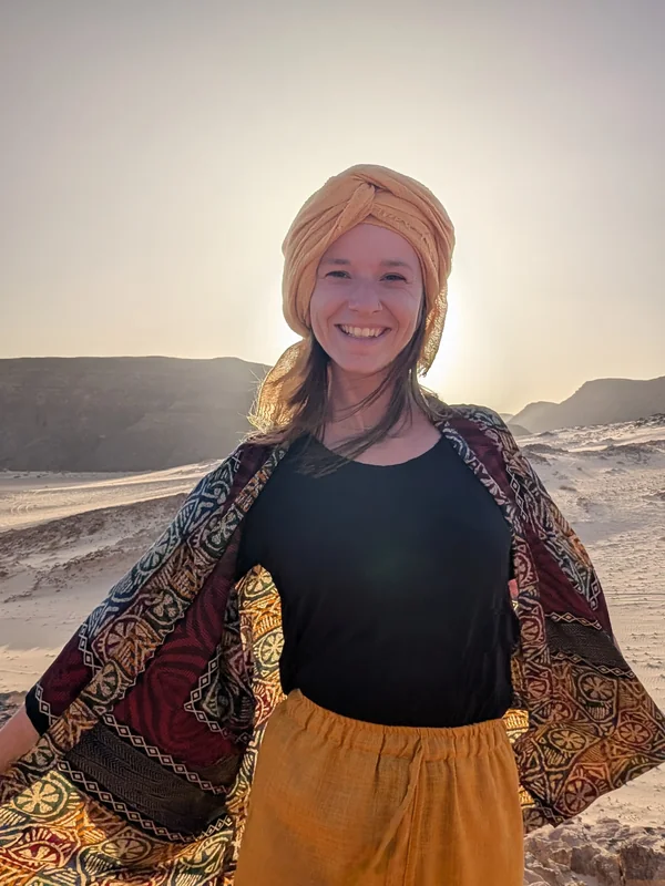 Elena Steinmann lächelt in der Wüste des Sinai mit Turban und buntem Tuch
