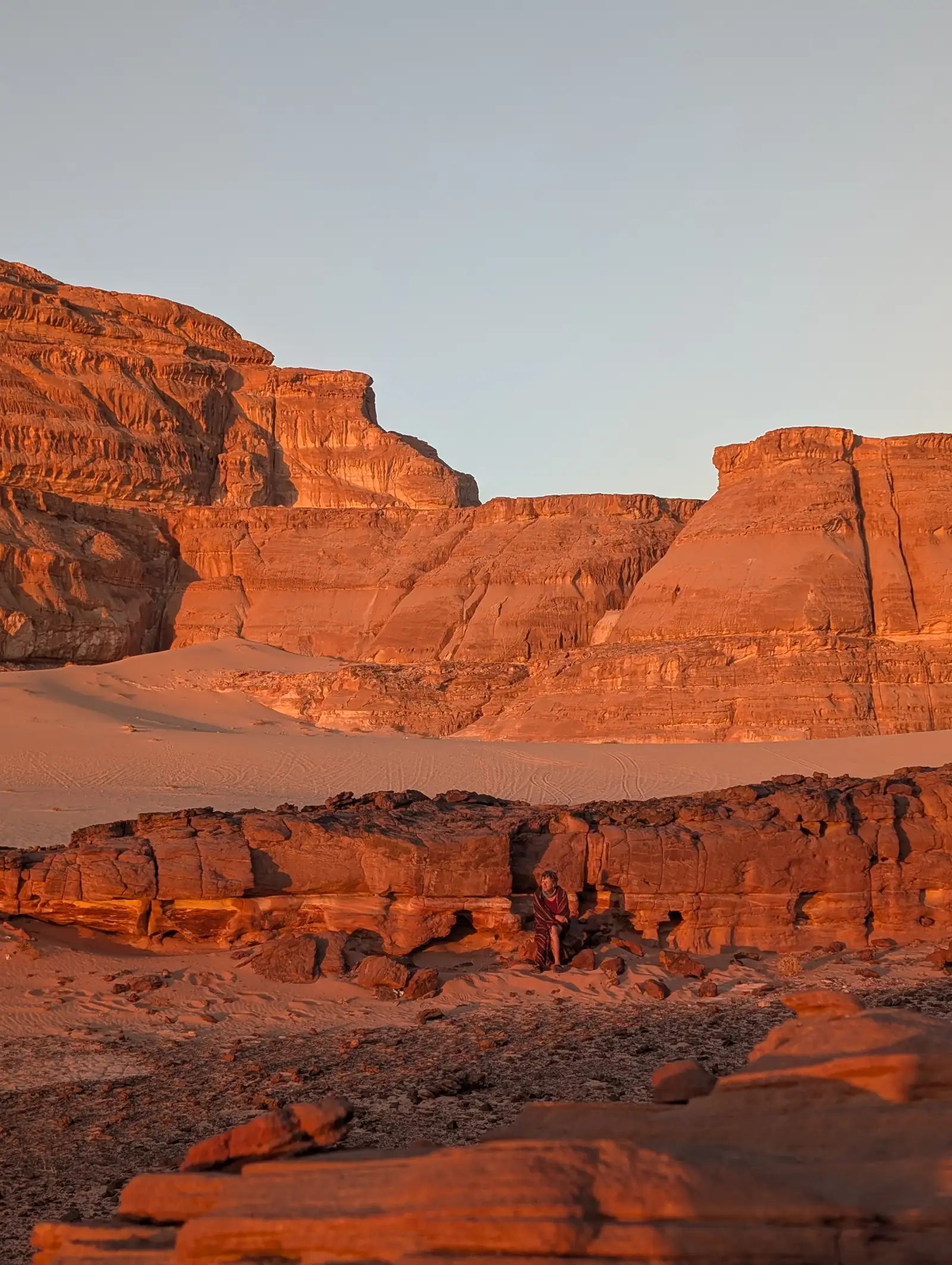 Zwei Menschen in der rot leuchtenden Felswüste des Sinai im Abendlicht