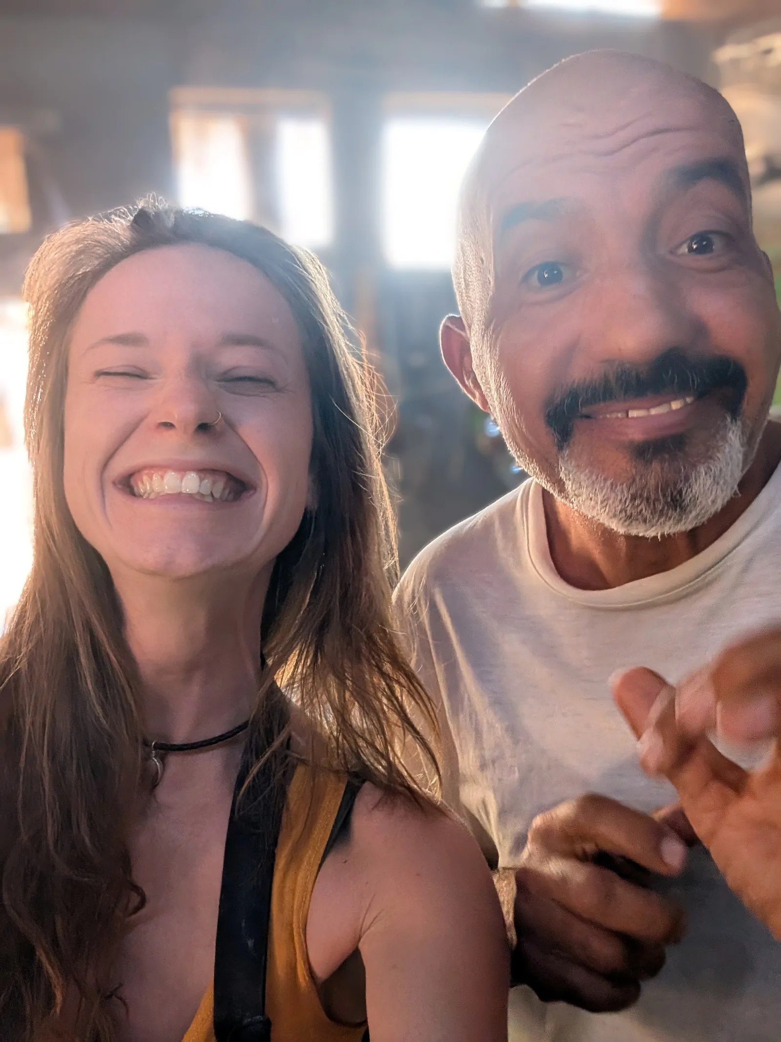 Elena lacht herzlich mit einem Mitarbeiter des RockSea Camps im warmen Gegenlicht in Nuweiba