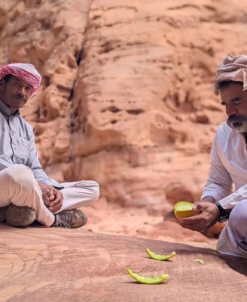 Swualim, Tarabin-Beduine und Wüstenführer, mit Melone auf rotem Sandstein im Süd-Sinai